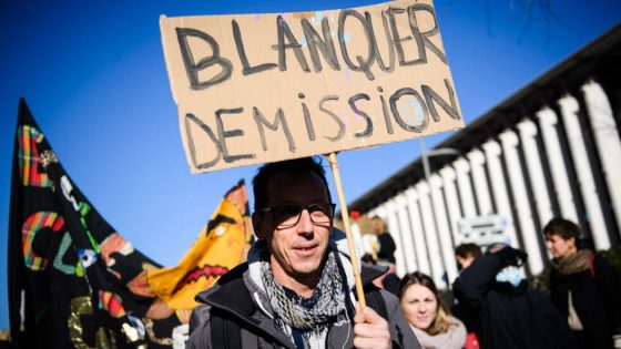 A protestor holds a placard reading "Jean-Michel Blanquer - resignation!" during a demonstration called by teachers' unions to denounce "an indescribable mess" because of the new government's measures agaisnt Covid-19, in Marseille, southern France, on January 13, 2022. - According to the forecasts of the Snuipp-FSU, the leading primary school union, 75% of primary school teachers may not go through the school gates on January 13, 2022, and half of them should therefore be closed. (Photo by CLEMENT MAHOUDEAU / AFP)