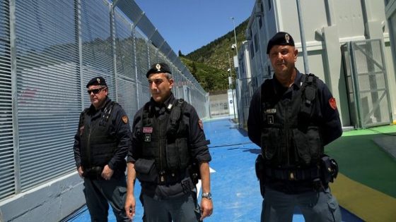 Italian police officers stand guard inside a recently build Italian-run migrant centre at the port of Shengjin, some 60 kms northwest of Tirana, on June 5, 2024. The controversial deal to host two holding centres for migrants rescued in Italian water, approved by Albania's parliament on February 2024 and regularly denounced by opposition parties in both countries as well as by rights groups, allows for two centres to be built near the Albanian port of Shengjin, where migrants would register for asylum, as well as a facility in the same region to house those awaiting a response to their applications. (Photo by Adnan Beci / AFP)